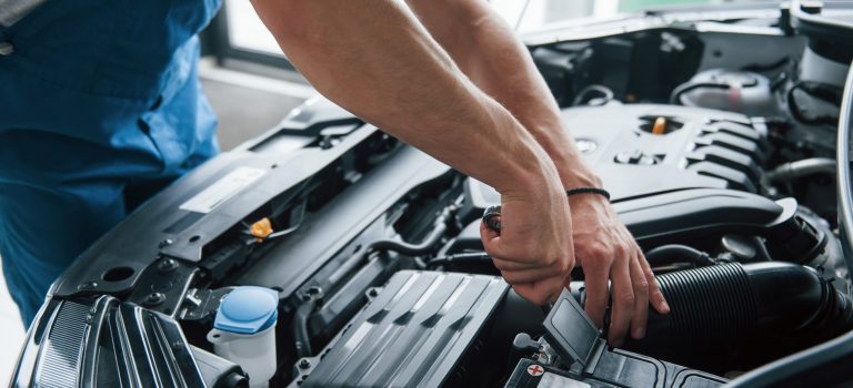Some electronic parts. Process of repairing car after accident. Man working with engine under the hood Some electronic parts. Process of repairing car after accident. Man working with engine under the hood.